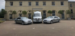 Two Claydon wedding cars and and executive coach in front of a smart building